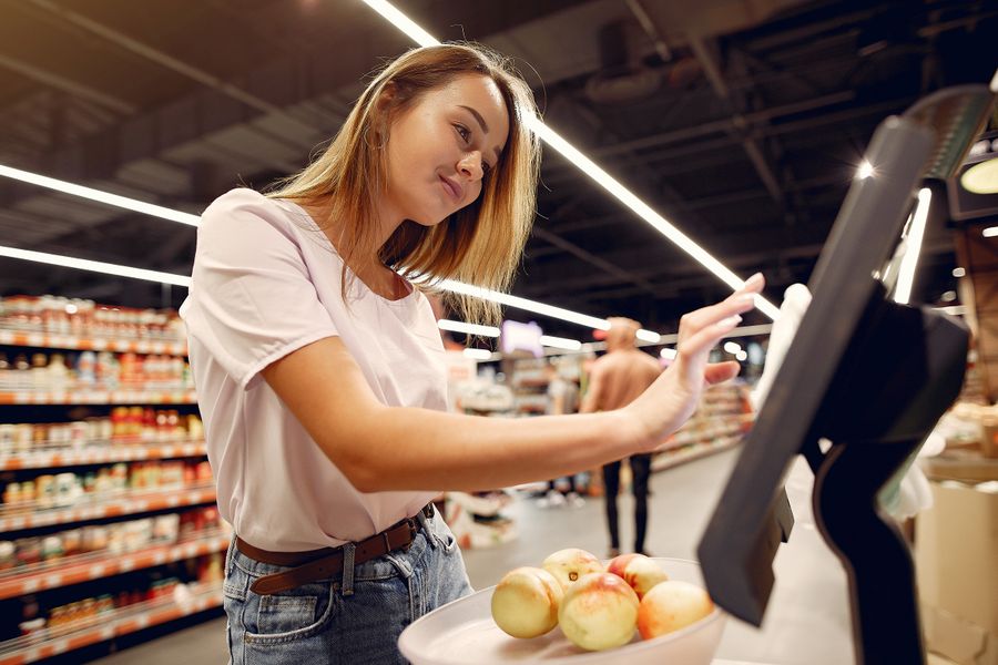 Mujer joven comprando frutas en supermercado